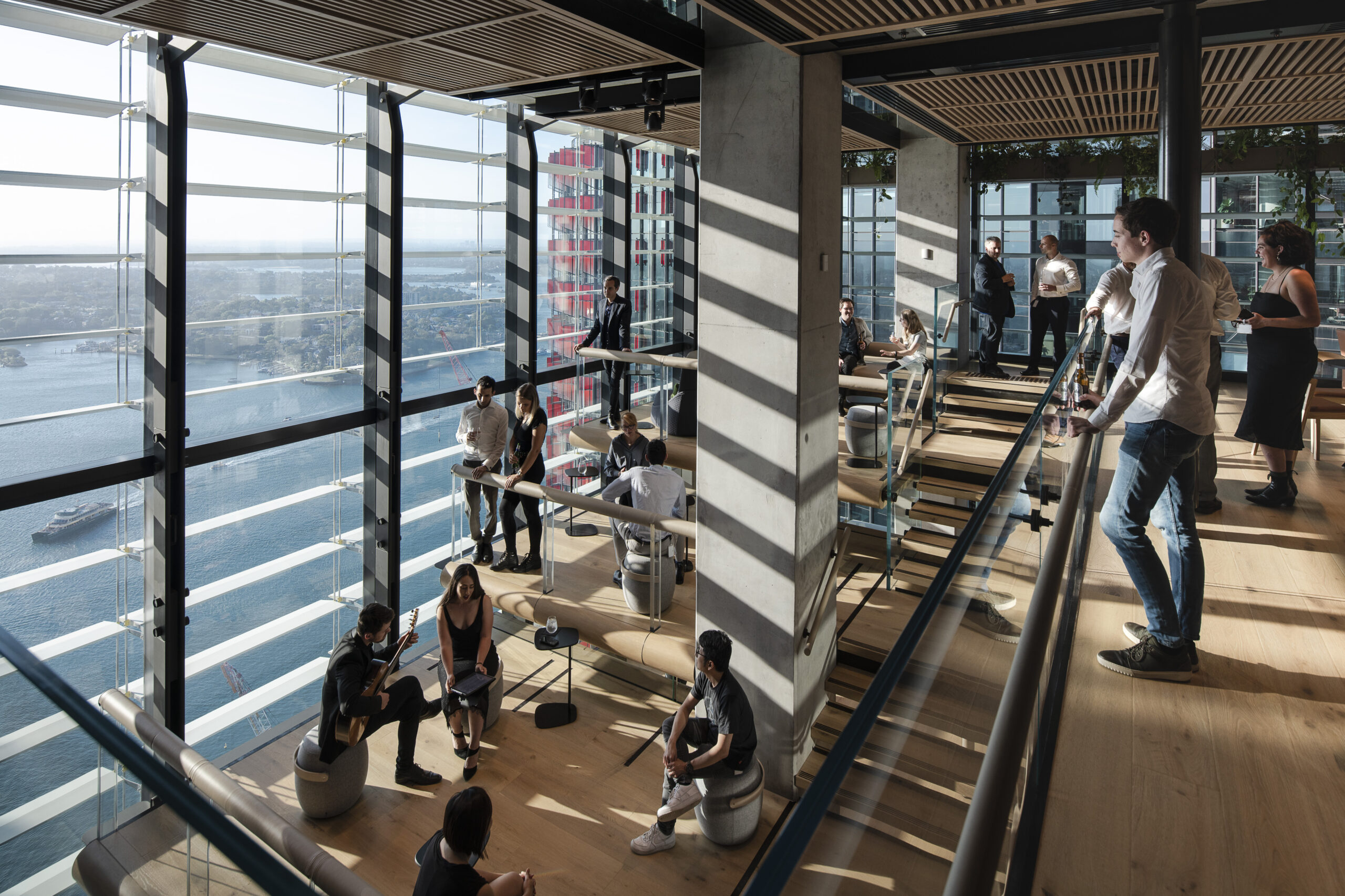 people in office. Large windows lookout to ocean.